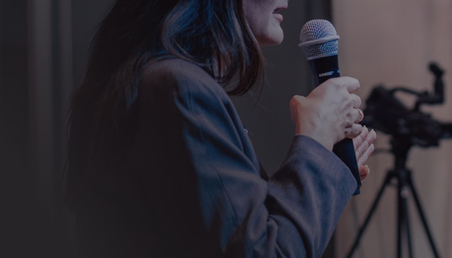 A woman speaking into a microphone.